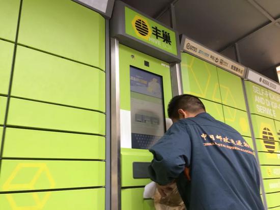 圖/一名快遞員正在往豐巢快遞柜投遞快遞。羅曉蘭攝